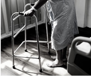 Elderly parent in a care home with walking frame