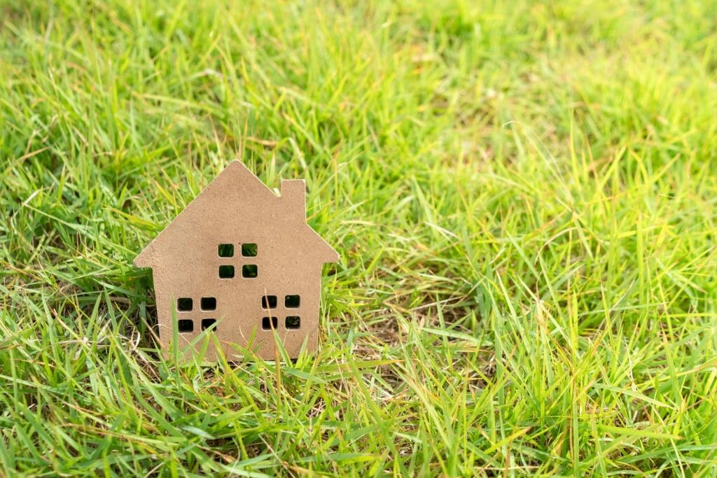 Closed up tiny home model on green grass with sunlight.